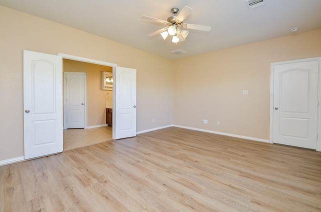 unfurnished room with ceiling fan, light wood-style flooring, visible vents, and baseboards