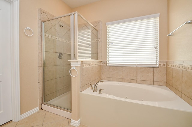 bathroom featuring tile patterned flooring, baseboards, a bath, and a shower stall