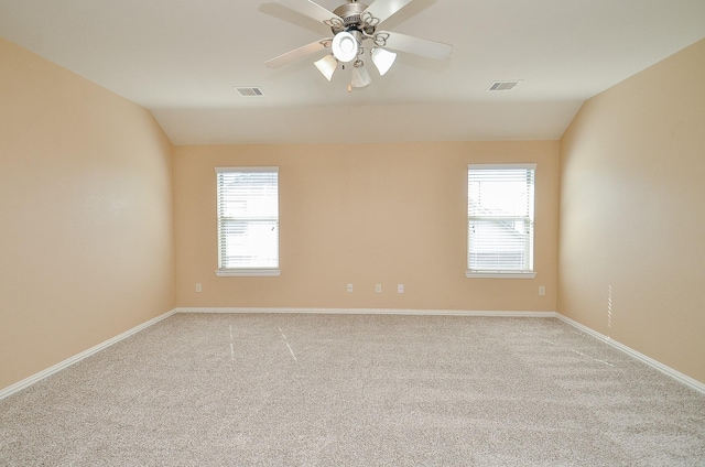 empty room with vaulted ceiling, plenty of natural light, and visible vents