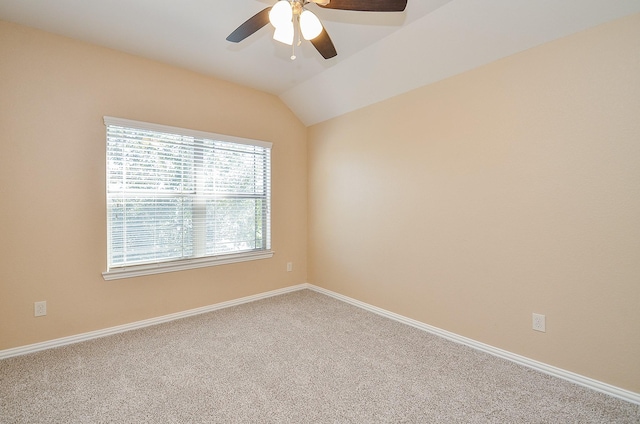 empty room with vaulted ceiling, carpet floors, a ceiling fan, and baseboards