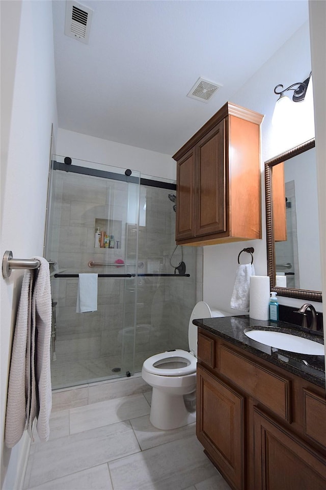 full bathroom with visible vents, a shower stall, toilet, and vanity