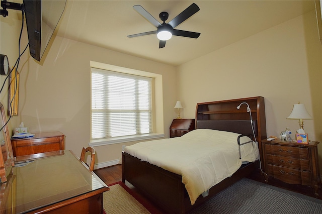 bedroom with a ceiling fan and dark wood-type flooring