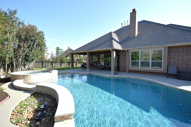 view of pool with a patio area, a fenced backyard, and a pool with connected hot tub