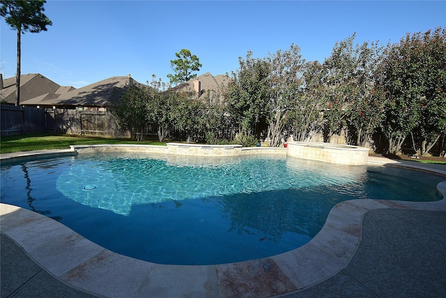 view of pool featuring a fenced backyard and a pool with connected hot tub