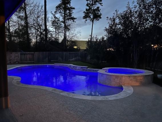 view of swimming pool with a patio area, a fenced backyard, and a pool with connected hot tub