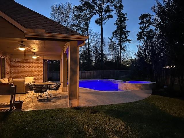 view of pool with fence private yard, a pool with connected hot tub, a ceiling fan, and a patio