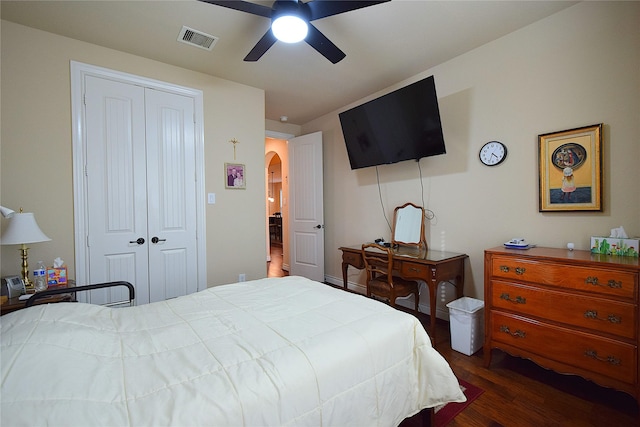 bedroom with visible vents, arched walkways, a ceiling fan, dark wood-type flooring, and a closet