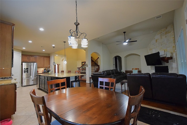 dining area featuring recessed lighting, visible vents, arched walkways, stairs, and ceiling fan with notable chandelier