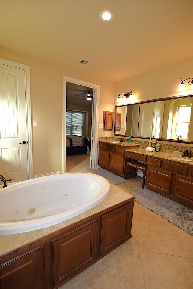 bathroom featuring a jetted tub, a sink, visible vents, and connected bathroom