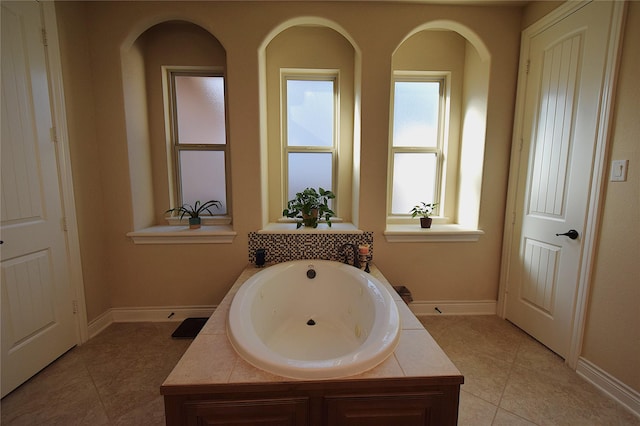 full bath with tile patterned flooring, baseboards, and a whirlpool tub