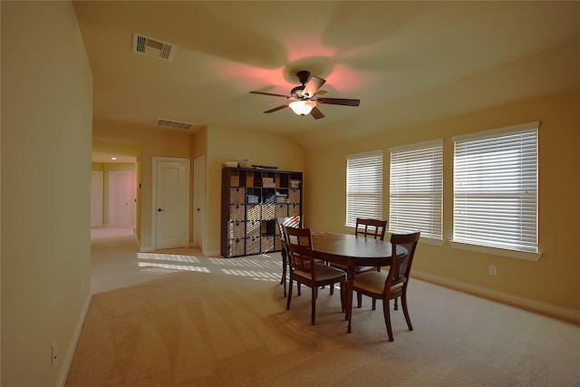 dining area featuring light colored carpet, visible vents, and baseboards