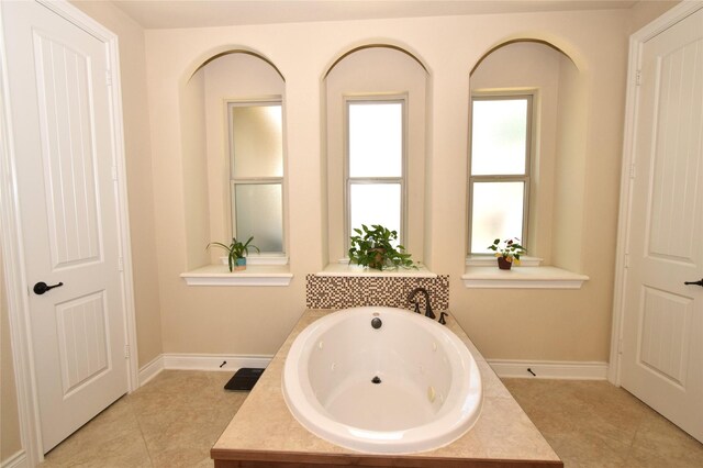 10010 Friesian Estates Dr, Spring, TX 77379 - bathroom featuring a tub with jets, baseboards, tile patterned floors, and a sink