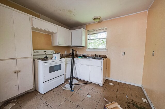 3113 1/2 Anita St Unit A B C, Houston, TX 77004 - kitchen featuring white range with electric cooktop, a sink, white cabinets, light tile patterned floors, and baseboards