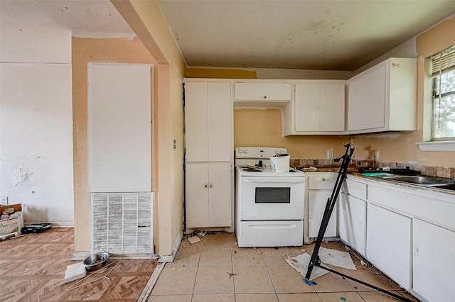 kitchen with white cabinets, white electric range, a sink, and light tile patterned floors