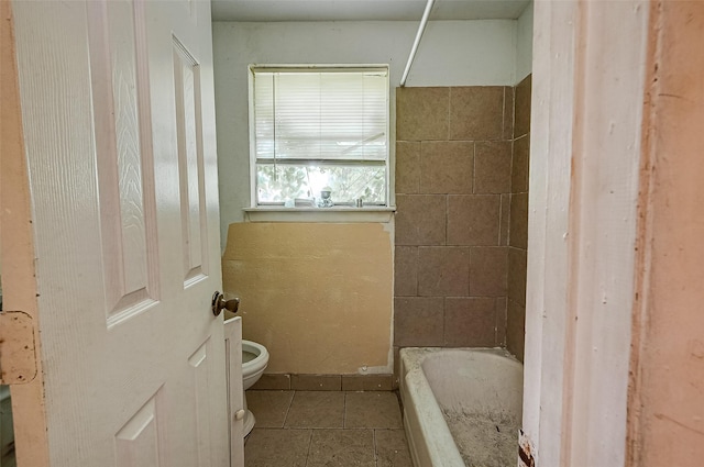 bathroom featuring a bath, walk in shower, tile patterned flooring, and toilet