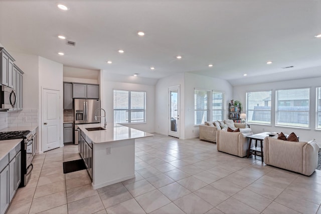 kitchen with visible vents, gray cabinets, appliances with stainless steel finishes, and open floor plan