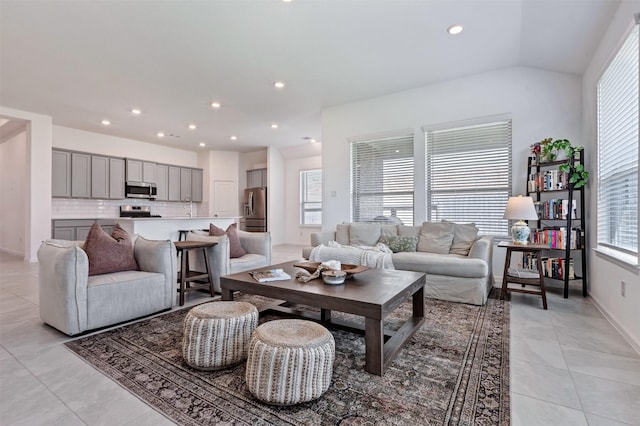 living area with light tile patterned floors, vaulted ceiling, baseboards, and recessed lighting