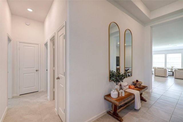 hallway with baseboards and light tile patterned flooring