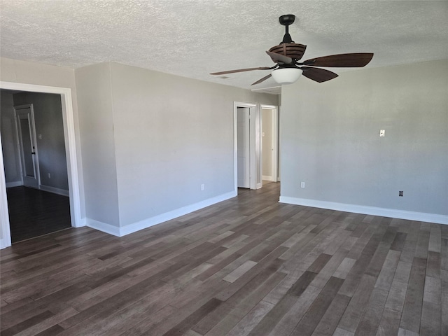 spare room with a textured ceiling, ceiling fan, dark wood finished floors, and baseboards