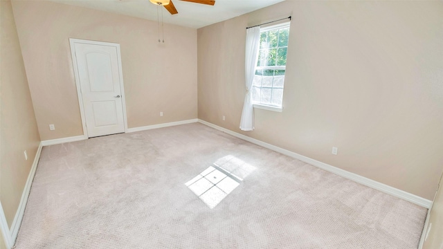 empty room with carpet, ceiling fan, and baseboards