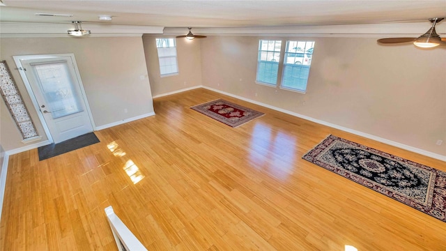 unfurnished living room featuring plenty of natural light, visible vents, ceiling fan, and wood finished floors