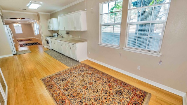 kitchen featuring arched walkways, white appliances, light wood-type flooring, and crown molding