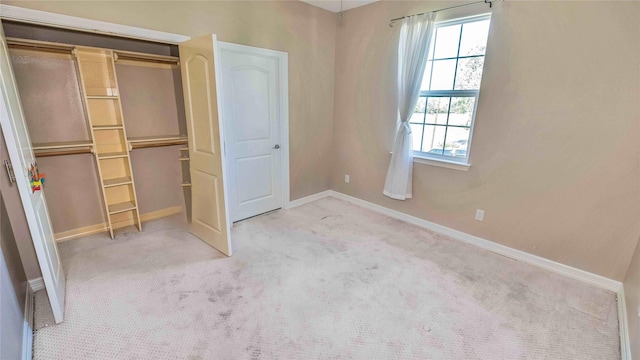 unfurnished bedroom with carpet floors, a closet, and baseboards