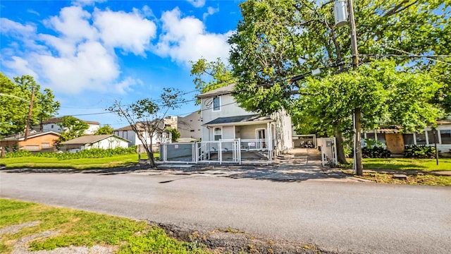 view of front of house with a gate, a residential view, and fence