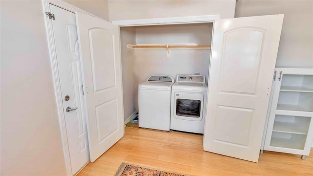 laundry area with light wood-type flooring, laundry area, and independent washer and dryer