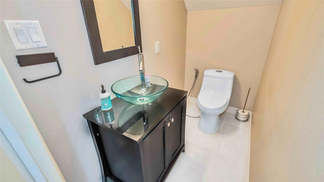 bathroom with toilet, baseboards, vanity, and tile patterned floors