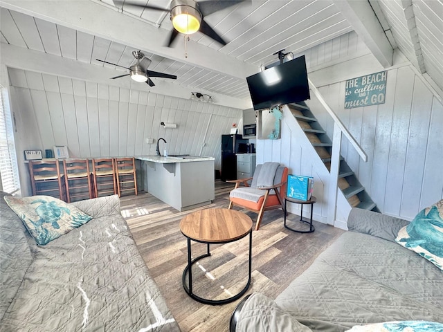 310 Angel Wing St, Surfside Beach, TX 77541 - living room with wooden walls, a ceiling fan, light wood-style flooring, stairway, and beam ceiling
