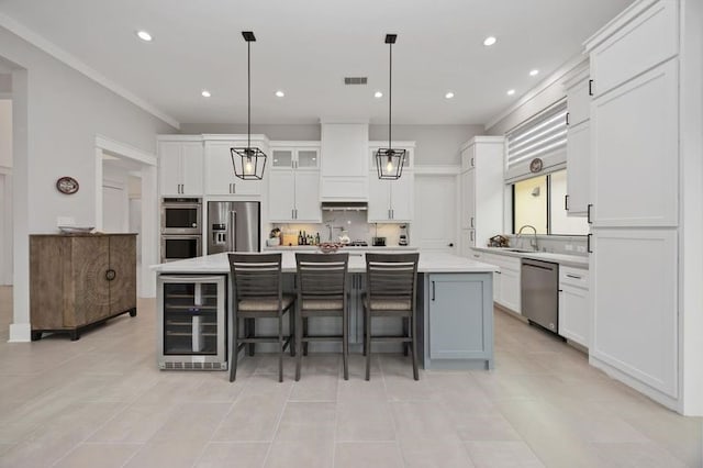 kitchen with beverage cooler, stainless steel appliances, visible vents, white cabinets, and light countertops