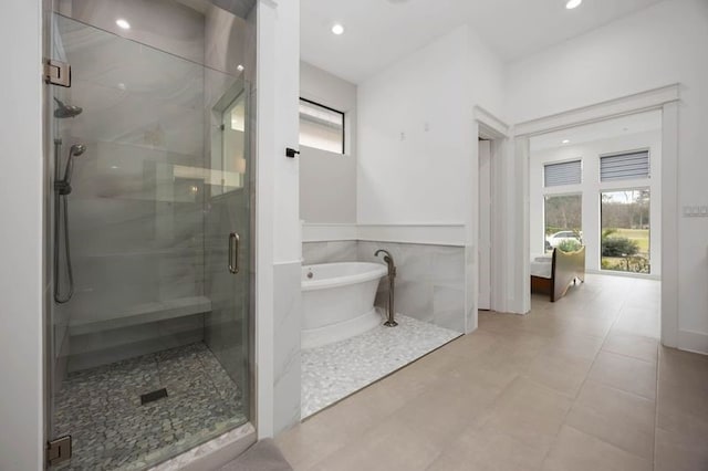 full bath featuring recessed lighting, a soaking tub, and a shower stall