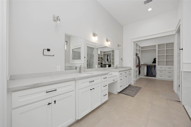 bathroom with visible vents, a spacious closet, vanity, and tile patterned floors