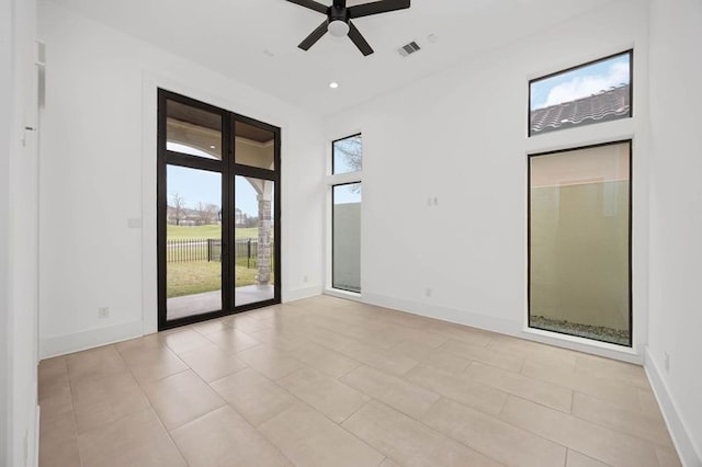 empty room with visible vents, baseboards, a ceiling fan, a towering ceiling, and recessed lighting