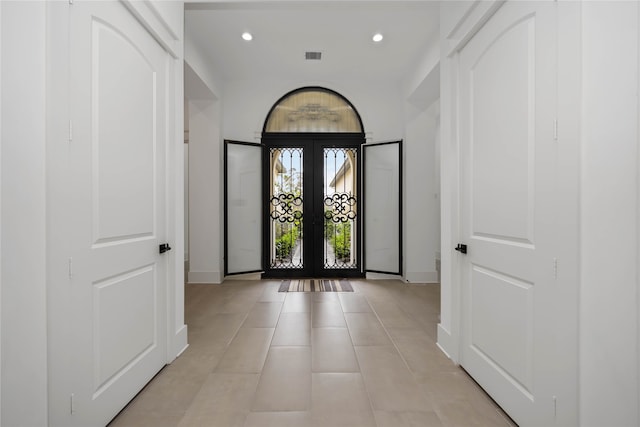 foyer with light tile patterned floors, visible vents, baseboards, french doors, and recessed lighting