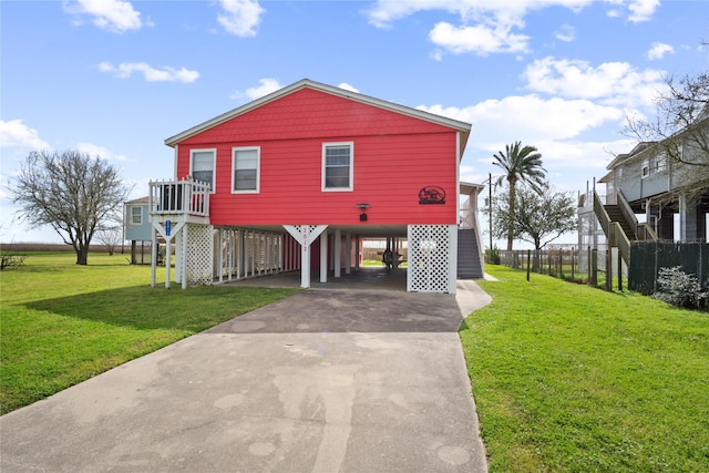 view of front of house with driveway, stairs, fence, a front lawn, and a carport