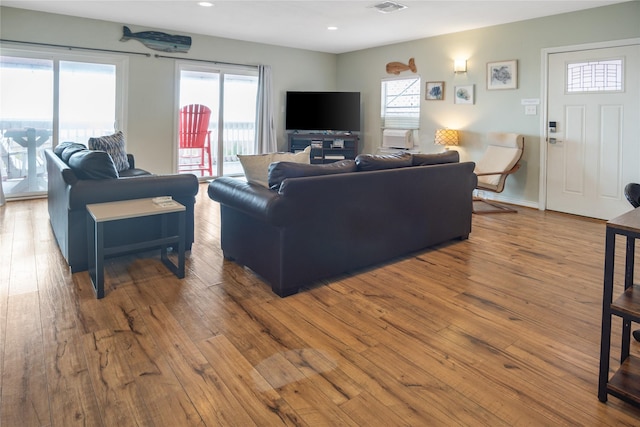 living area with visible vents, wood-type flooring, baseboards, and recessed lighting
