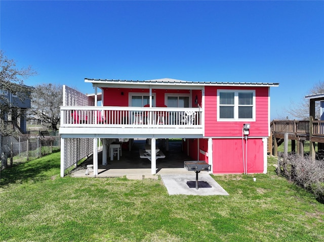back of house with a yard, a wooden deck, and metal roof
