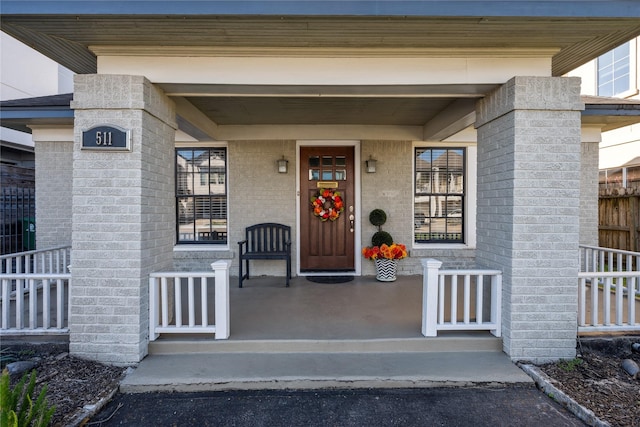 entrance to property with brick siding and fence