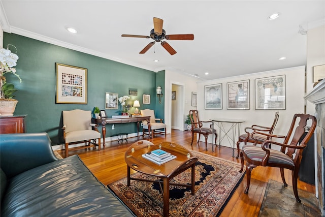 living room featuring baseboards, recessed lighting, wood finished floors, and crown molding