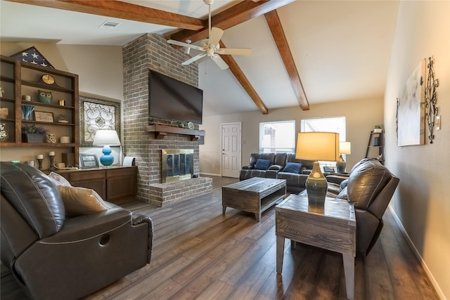 living room featuring baseboards, visible vents, wood finished floors, a brick fireplace, and beam ceiling