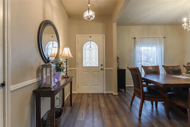 entryway with a notable chandelier, baseboards, and dark wood-type flooring