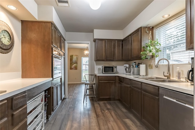 kitchen with light countertops, appliances with stainless steel finishes, a sink, and visible vents