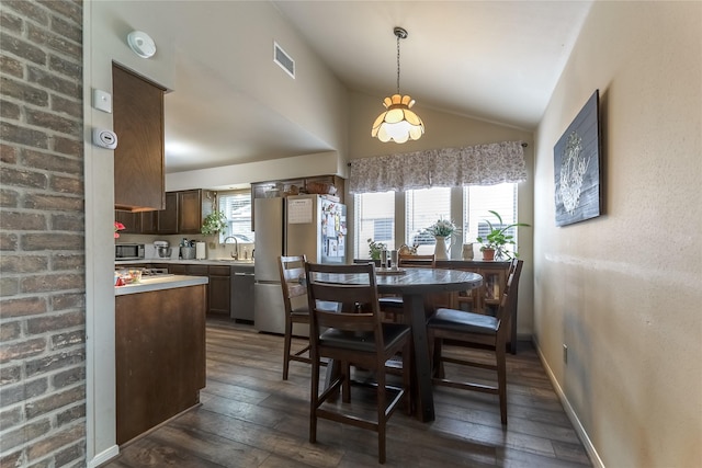 dining room with lofted ceiling, visible vents, dark wood finished floors, and baseboards