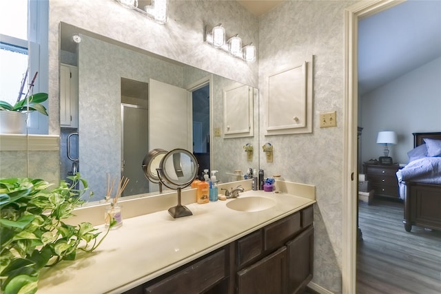 full bathroom featuring a shower with door, wood finished floors, vanity, and connected bathroom