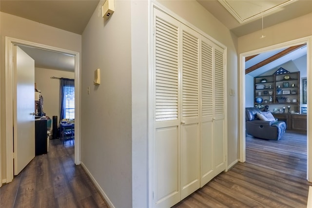 hall featuring attic access, baseboards, and dark wood-style floors