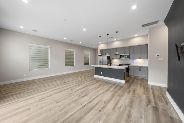 kitchen featuring visible vents, light wood-style flooring, appliances with stainless steel finishes, light countertops, and gray cabinetry