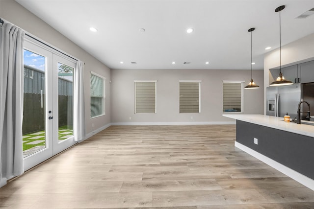 unfurnished living room featuring french doors, light wood-type flooring, visible vents, and recessed lighting