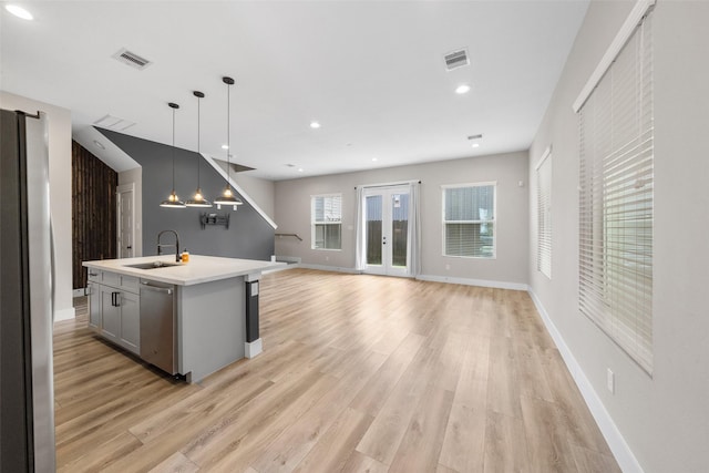 kitchen featuring visible vents, stainless steel appliances, a sink, and light countertops